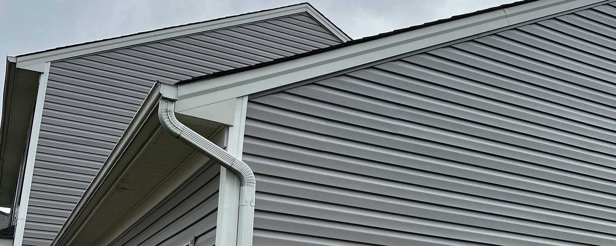 Gables of a house with vinyl siding in grey.